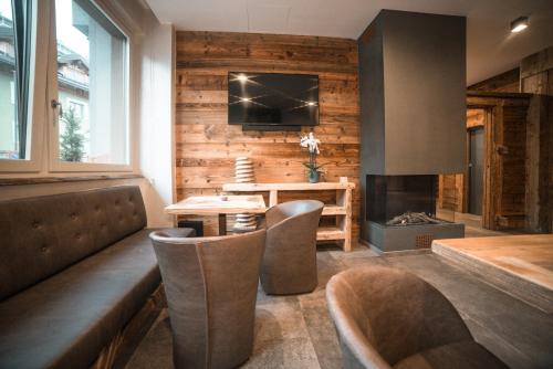 a living room with a table and a fireplace at Serendipity Hotel in Sauze dʼOulx