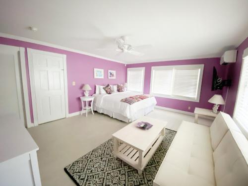 a bedroom with a white bed and purple walls at Authors Key West Guesthouse in Key West