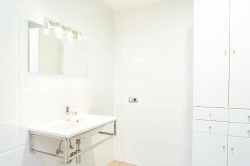 un bagno bianco con lavandino e specchio di Valencia Luxury - Boutique Center a Valencia