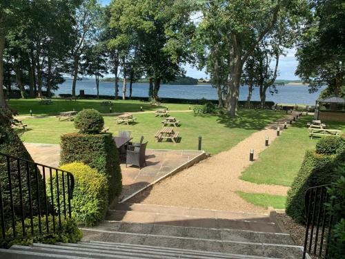 a park with tables and benches and a body of water at Normanton Park Hotel, Sure Hotel Collection by Best Western in Oakham