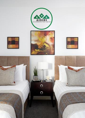 two beds sitting next to each other in a bedroom at Aisiki Living at Upton Road, Multiple 1, 2, or 3-Bedroom Apartments, King or Twin Beds with Free Wi-Fi & Parking Space in Watford