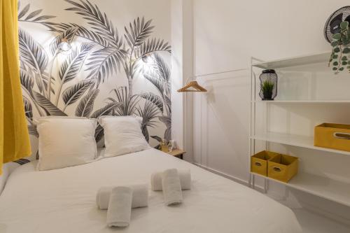 - une chambre avec un lit blanc et un papier peint tropical dans l'établissement DIFY Gouraud - Lyon 8, à Lyon