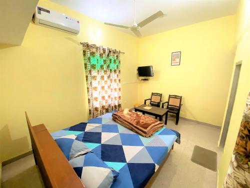 Schlafzimmer mit einem Bett, einem Tisch und einem TV in der Unterkunft TOURIST LODGE in Surajpur Jikkla