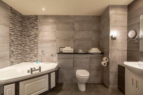 a bathroom with a tub and a toilet and a sink at Carrickdale Hotel & Spa in Dundalk