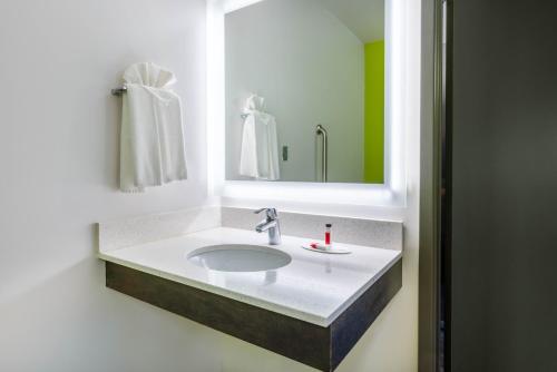 a bathroom with a sink and a mirror at Super 8 by Wyndham Winnipeg East MB in Winnipeg