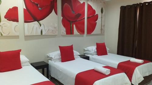 a room with two beds with red pillows at Gecko Inn in Richards Bay