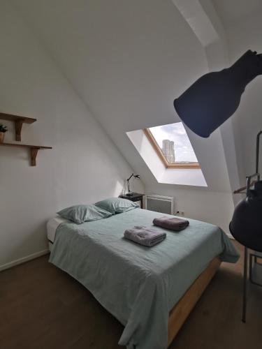 une chambre avec un lit avec deux serviettes dessus dans l'établissement Suite de l'Etape - Vue cathédrale, à Reims