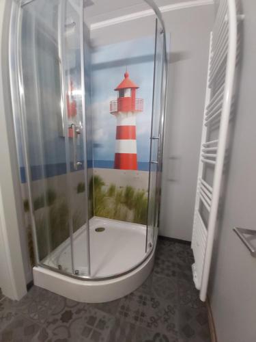 a bathroom with a shower with a lighthouse painted on the wall at Motel-Stuhr in Stuhr