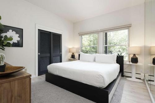 a white bedroom with a bed and a window at Durant 6D in Aspen