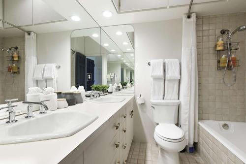 a white bathroom with two sinks and a toilet at Durant 6D in Aspen