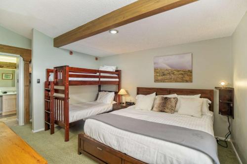 a bedroom with two beds and a book shelf at Lichenhearth 31 in Snowmass Village