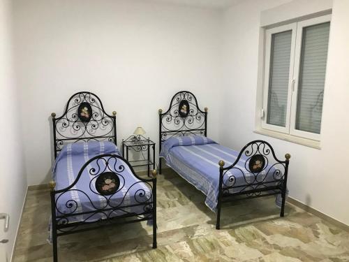 two twin beds in a room with a window at Residence Anna - Red Apartment in Roseto degli Abruzzi
