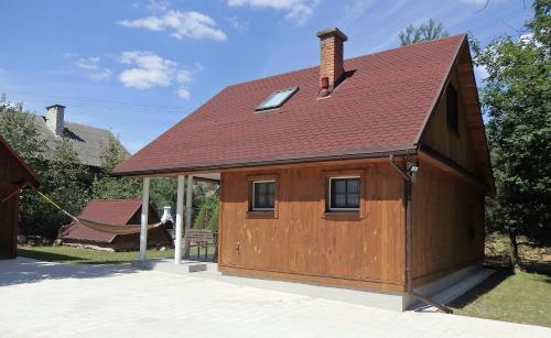 un gran edificio de madera con techo rojo en Godzisz - domek rekreacyjny, en Sobolew