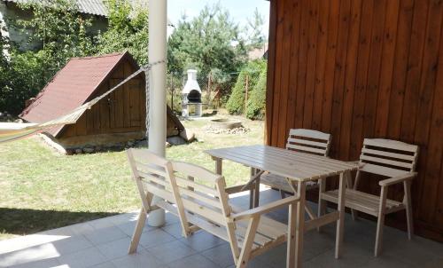 una mesa de madera y sillas en un patio en Godzisz - domek rekreacyjny, en Sobolew