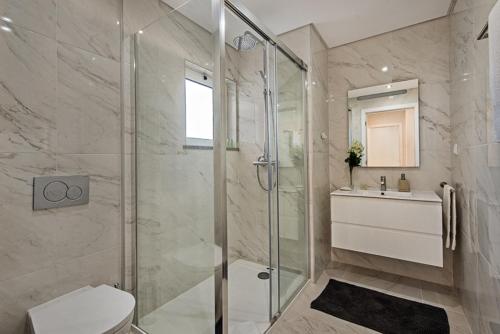a bathroom with a shower and a toilet and a sink at Apartamento Markus in Tavira