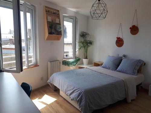 a bedroom with a bed and a large window at Appartement dernier étage Hyper Centre in Granville