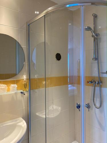 a bathroom with a glass shower with a sink at Hotel Credible in Nijmegen