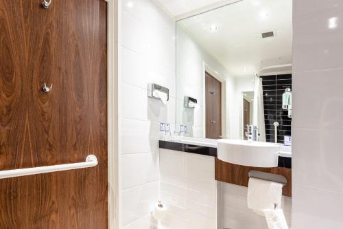 a bathroom with a toilet, sink, and mirror at Holiday Inn Express Edinburgh Airport, an IHG Hotel in Ingliston