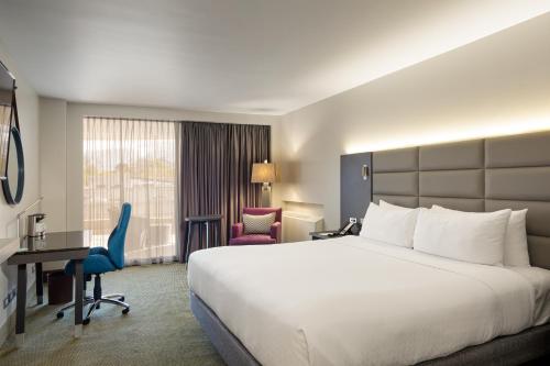 una camera d'albergo con un grande letto e una scrivania di Crowne Plaza San Jose La Sabana, an IHG Hotel a San José