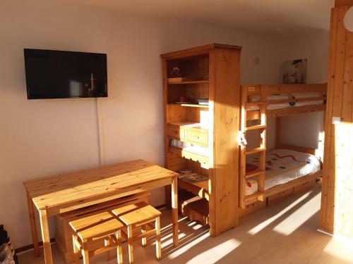 Cette chambre dispose d'un bureau, de lits superposés, d'un bureau et d'une table. dans l'établissement Ski Soleil 304, à Manigod