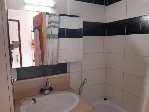 une salle de bain avec un lavabo et un miroir dans l'établissement Ski Soleil 304, à Manigod