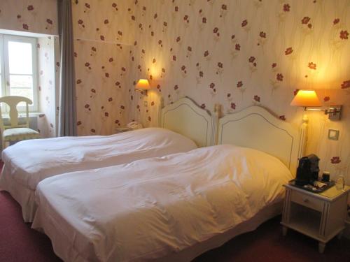 a bedroom with a white bed with flowers on the wall at Château des Monthairons Hôtel Restaurant GastroMaison Spa privatif in Les Monthairons