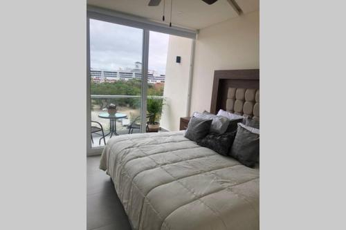 a bedroom with a large bed and a large window at Departamento Ambar en Puerto Vallarta in Puerto Vallarta
