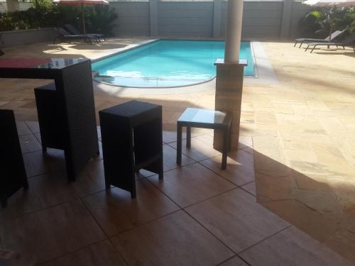 a pool with a table and two chairs and a table andools at Shanzu Beach apartment with stunning Ocean view in Mwakirunge