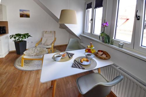 a white table with food on it in a living room at Pretti Apartments - NEUES modern eingerichtetes Apartment - mitten im Stadtzentrum in Bamberg