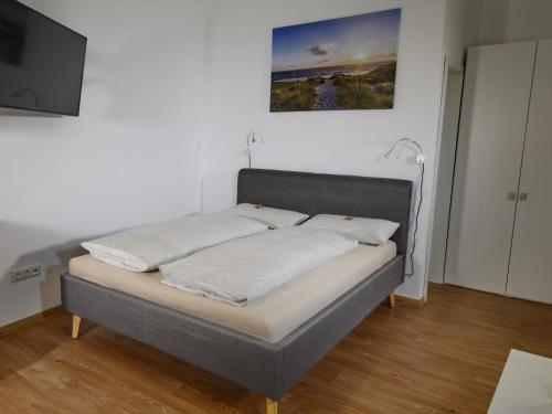 uma cama num quarto com uma televisão de ecrã plano em Pretti Apartments - NEUES stilvoll eingerichtetes Apartment im Zentrum von Bamberg em Bamberg