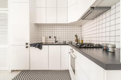 ワルシャワにあるRent like home - Wilcza 22Aの白黒のタイル張りの白いキッチン