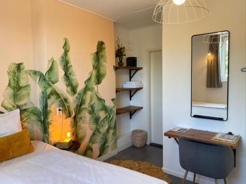 a bedroom with a bed and a desk and a mirror at Hotel Credible in Nijmegen