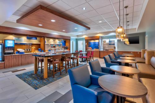 a restaurant with tables and chairs and a bar at Holiday Inn Express & Suites - Effingham, an IHG Hotel in Effingham
