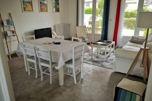 un salon avec une table et des chaises blanches dans l'établissement Leshorizonsperrosguirec, à Perros-Guirec