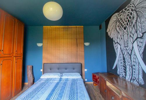 a bedroom with a bed and a blue wall at The Lodge in San Siro