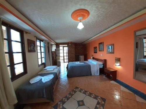 Duas camas num quarto com paredes e janelas cor-de-laranja em Hotel Pousada Viking em Jacumã