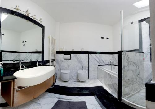 a bathroom with a sink and a tub and a toilet at STUPENDA MANSARDA CENTRALISSIMA, finiture di lusso in Carrara