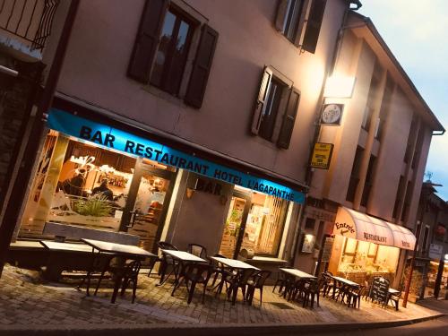un ristorante con tavoli e sedie di fronte a un edificio di Hotel Restaurant L'AGAPANTHE a Pont-de-Salars