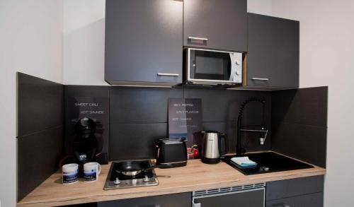 a small kitchen with a counter top with a microwave at Landhaus Amelinghausen Ferienzimmer in Amelinghausen