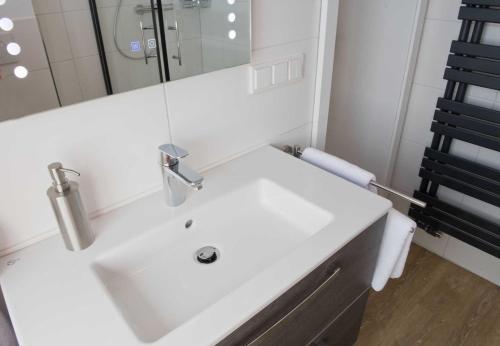 a bathroom with a white sink and a mirror at Landhaus Amelinghausen Ferienzimmer in Amelinghausen