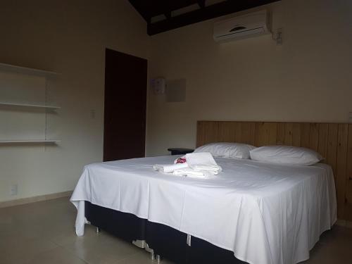 a bedroom with a bed with a white towel on it at Vila Figueiredo das Donas in Bombinhas