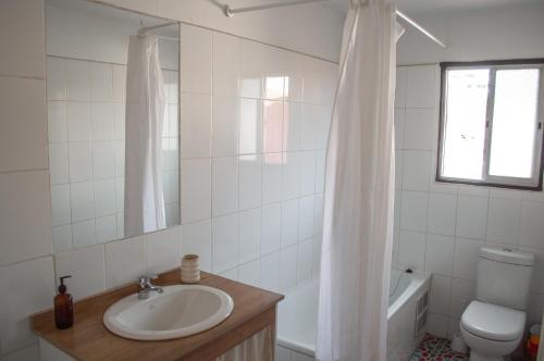 y baño con lavabo, aseo y espejo. en Eco-Hostal Tambo Verde, en Santiago