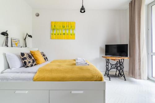 ワルシャワにあるRent like home - Wilcza 22Aのベッドルーム1室(黄色い毛布付きのベッド1台付)