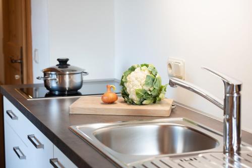una encimera de cocina con fregadero y una piña en una tabla de cortar en Göllerhof, en Caldaro