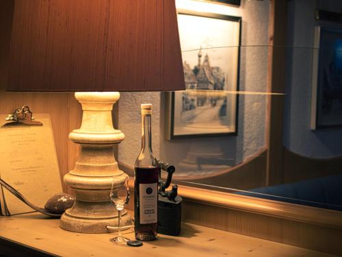 eine Flasche Wein und eine Lampe auf dem Tisch in der Unterkunft Neckarblick SELF Check IN Hotel in Bad Wimpfen