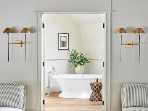 a bathroom with a white tub and a plant at The White Barn Inn & Spa, Auberge Collection in Kennebunk