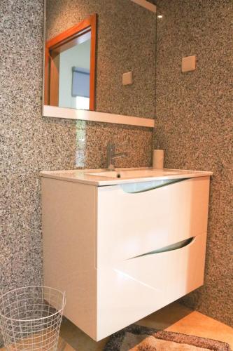 a bathroom with a sink and a mirror at Turisalves- Ponte de Lima in Ponte de Lima