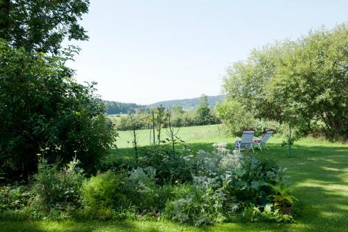 2 sillas en un jardín con flores y árboles en Ferienwohnung Schreiner, en Hohenau