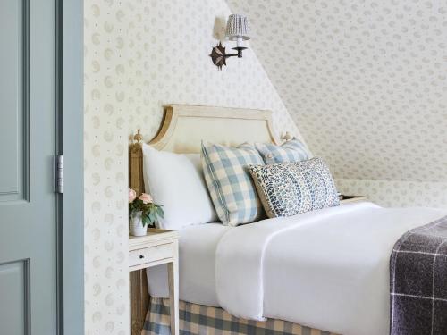 a bedroom with a white bed and a table with pillows at The White Barn Inn & Spa, Auberge Collection in Kennebunk