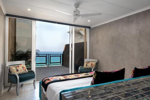 a bedroom with a bed and a view of the ocean at Sea front designer apartment in Ballito